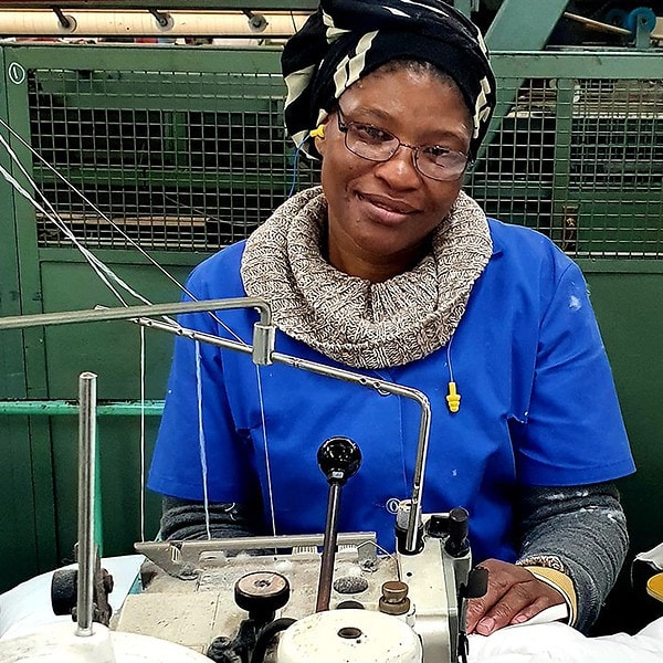 Romatex employee sitting behind a sewing machine
